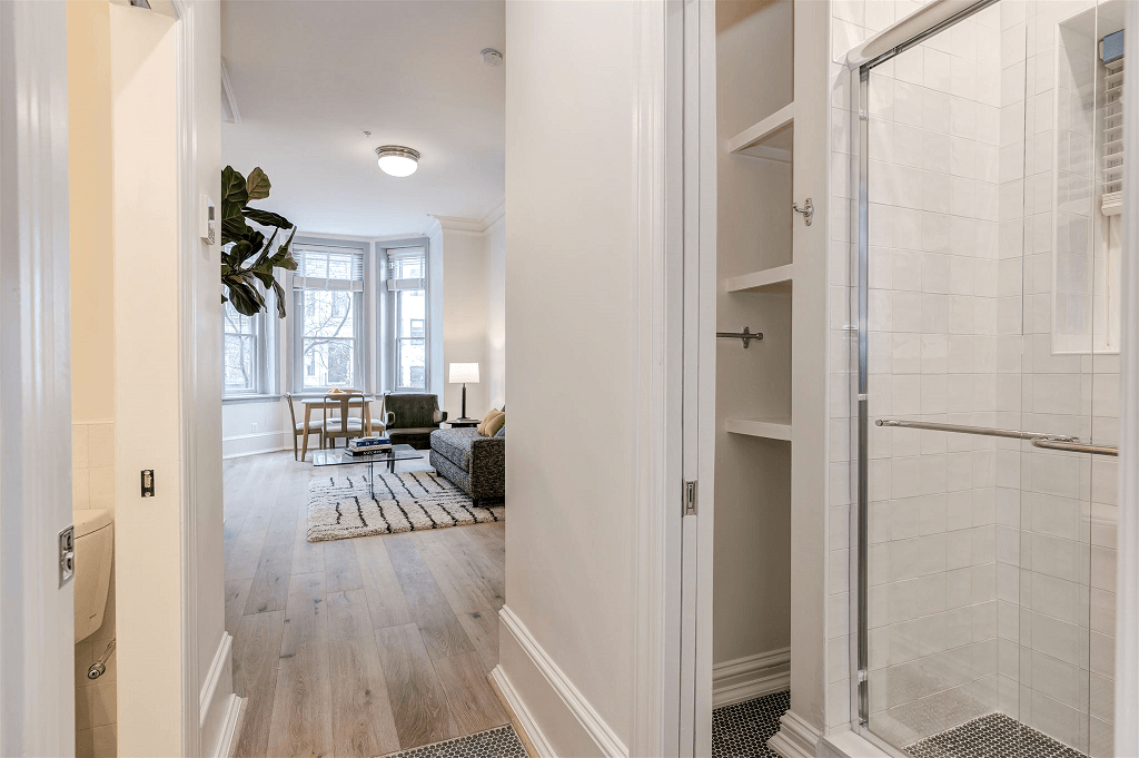 a bathroom with a shower and a living room with a couch